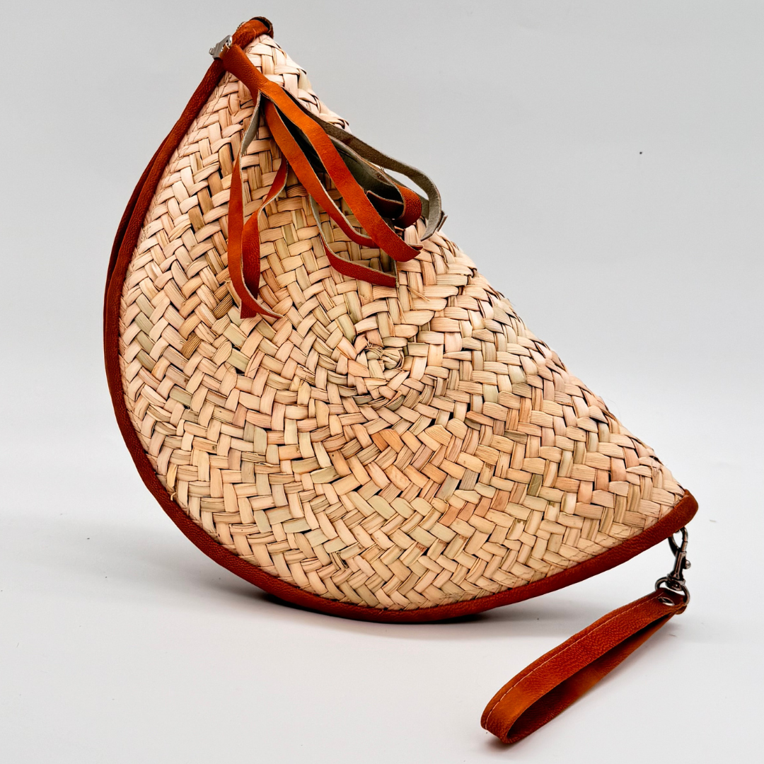 Halbmondförmige, handgewebte Strohclutch mit brauner Lederumfassung, Leder-Armbandriemen und dekorativer Quaste