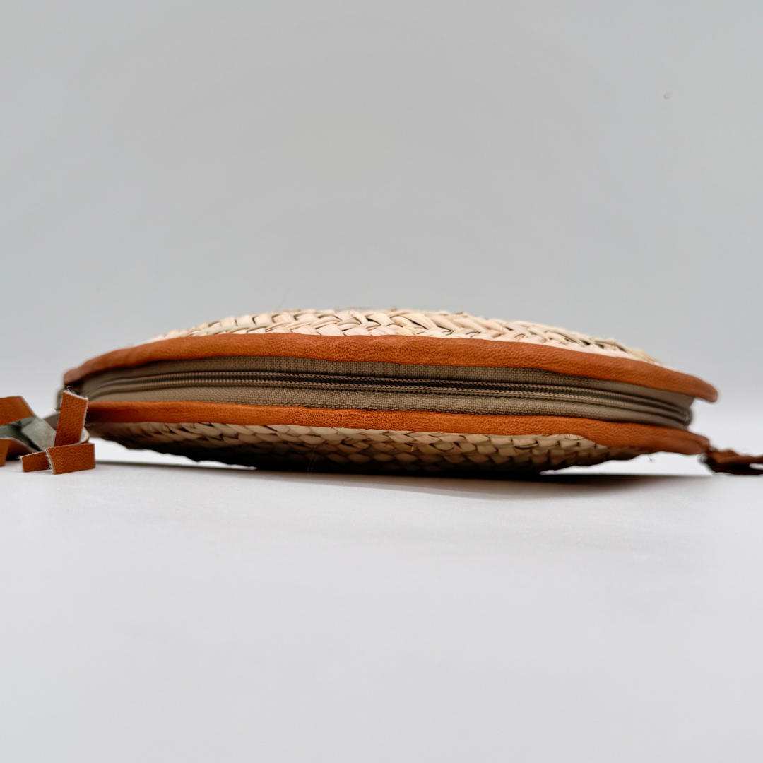 Halbmondförmige, handgewebte Strohclutch mit brauner Lederumfassung, Leder-Armbandriemen und dekorativer Quaste