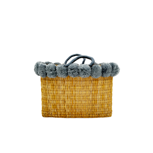 Handgewebte rechteckige Basttasche aus Naturstroh mit grauen Pompons am oberen Rand und kurzen Schlaufen aus Bast