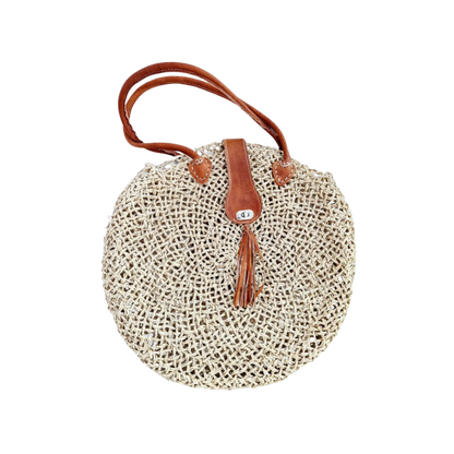 Runde, handgewebte Basttasche aus grobem Raffia mit braunem Lederüberschlag, Quastenanhänger und zwei Lederhenkeln
