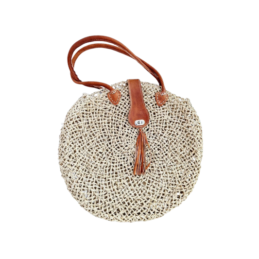 Runde, handgewebte Basttasche aus grobem Raffia mit braunem Lederüberschlag, Quastenanhänger und zwei Lederhenkeln