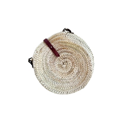 Runde, handgewebte Basttasche aus Palmstroh mit verstellbarem, schmalem braunem Lederriemen als Schultergurt