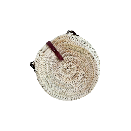 Runde, handgewebte Basttasche aus Palmstroh mit verstellbarem, schmalem braunem Lederriemen als Schultergurt