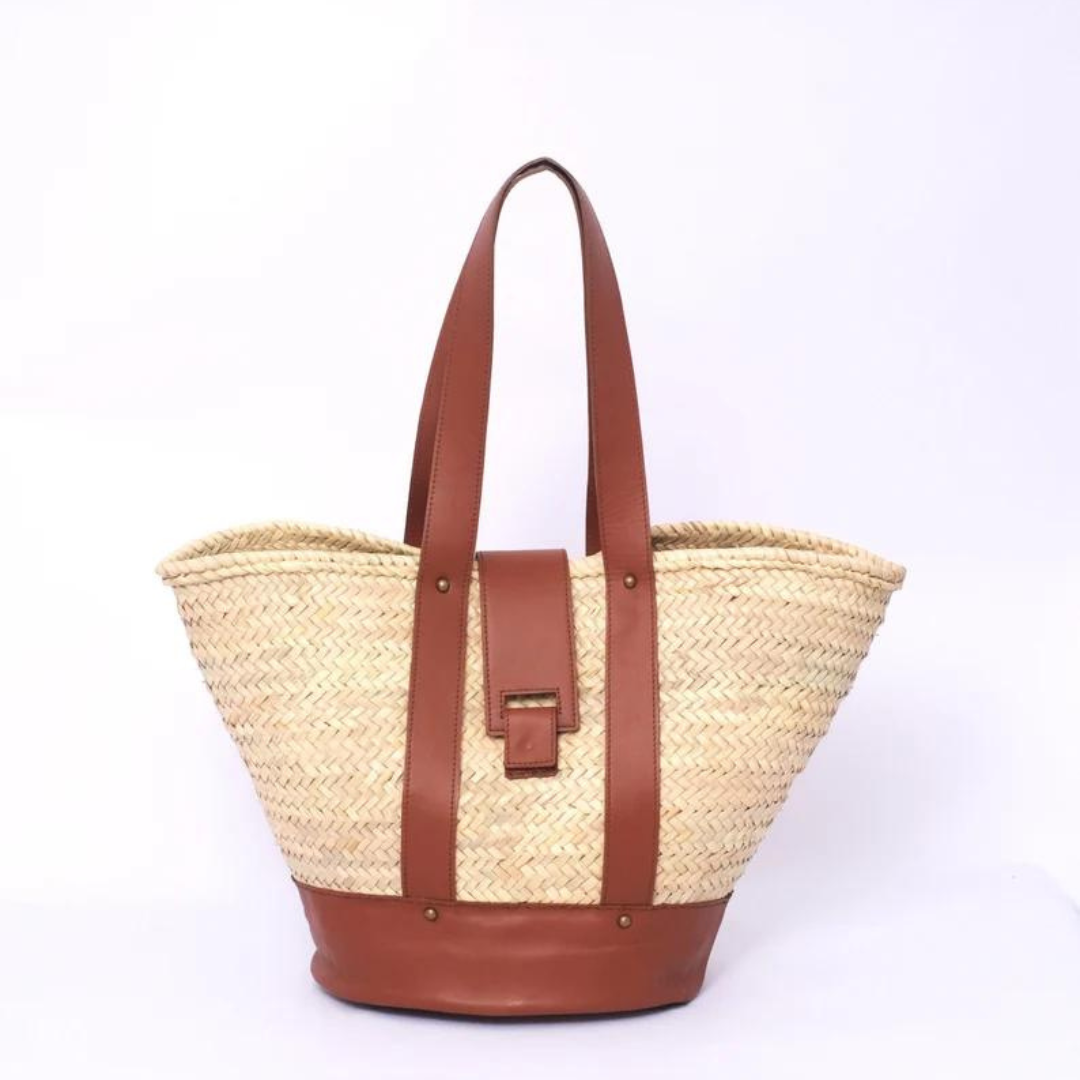 Handgewebte Strohtasche aus Palmstroh mit braunem Lederboden, zwei langen Lederhenkeln und zentralem Lederüberschlag mit Magnetverschluss