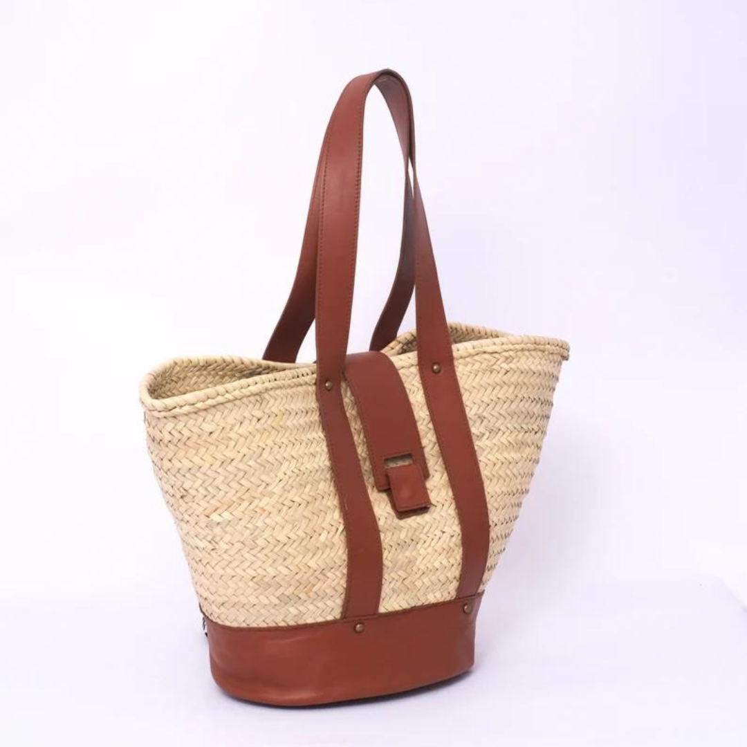 Handgewebte Strohtasche aus Palmstroh mit braunem Lederboden, zwei langen Lederhenkeln und zentralem Lederüberschlag mit Magnetverschluss