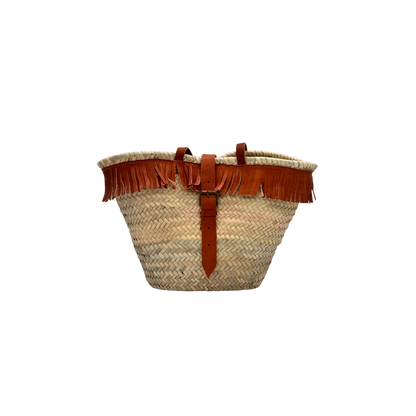 Handgewebte Basttasche aus Naturstroh mit braunen Lederfransen am oberen Rand und verstellbarem Lederriemen als Verschluss