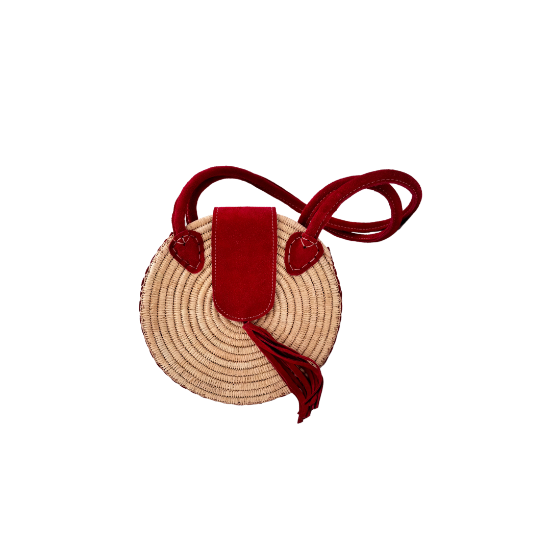 Runde, handgewebte Basttasche aus Rafia mit rotem Wildlederüberschlag, rotem Schulterriemen und dekorativer Quaste