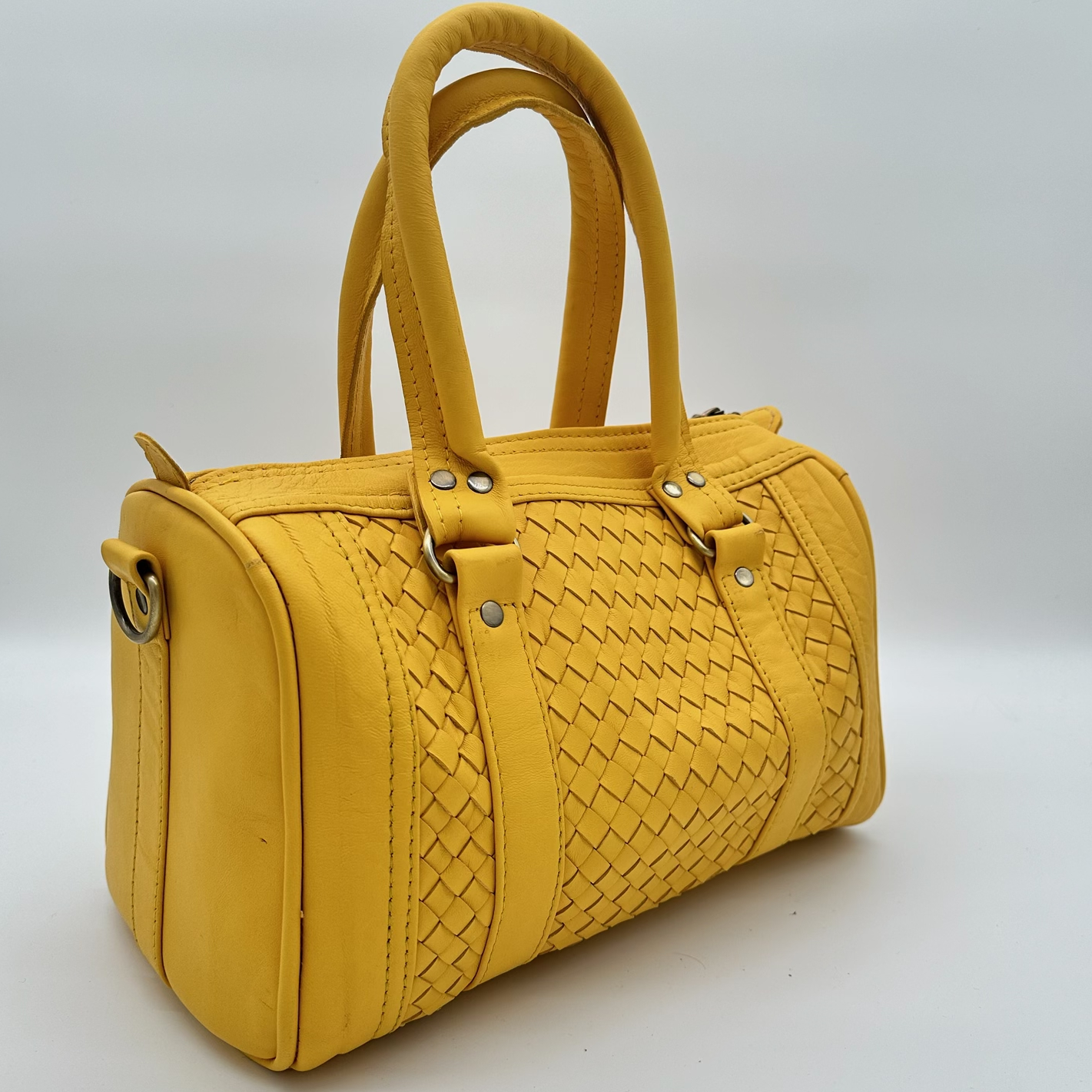 Kastenförmige Handtasche aus senfgelbem Leder mit geflochtenem Mittelteil, zwei Lederhenkeln und Reißverschluss