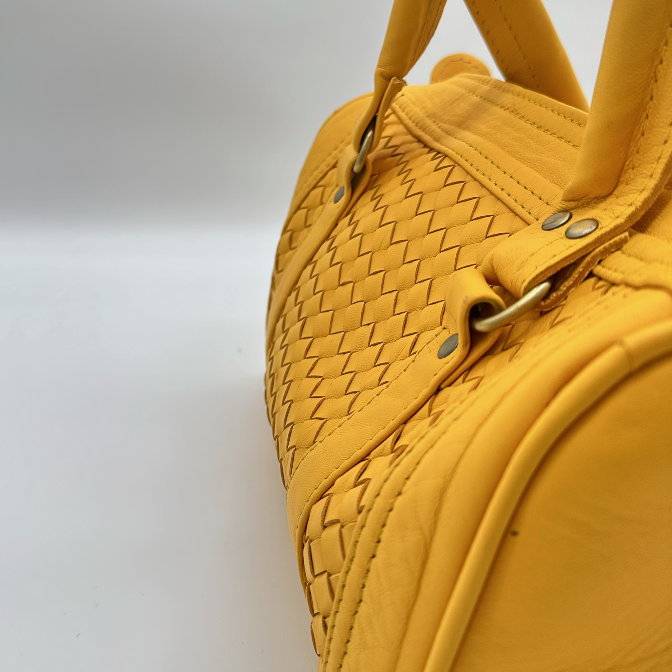 Kastenförmige Handtasche aus senfgelbem Leder mit geflochtenem Mittelteil, zwei Lederhenkeln und Reißverschluss