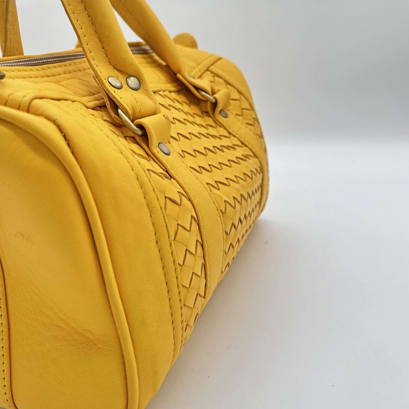 Kastenförmige Handtasche aus senfgelbem Leder mit geflochtenem Mittelteil, zwei Lederhenkeln und Reißverschluss